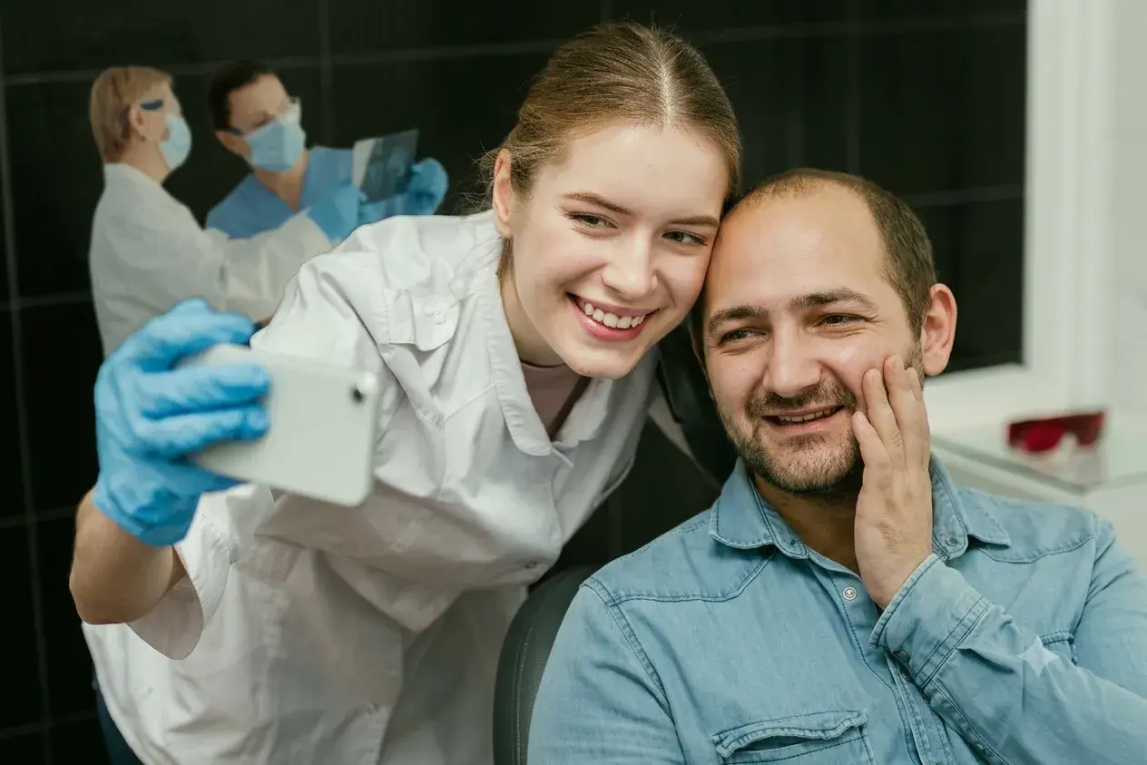 Dentist taking a selfie with a smiling patient in the clinic