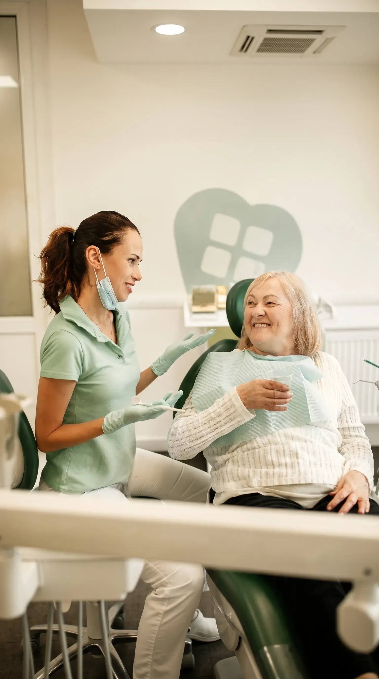 A dentist talking with a seated patient during a comprehensive care consultation