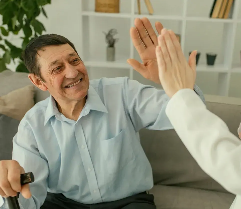 A happy patient high-fiving his dentist, pleased with his treatment